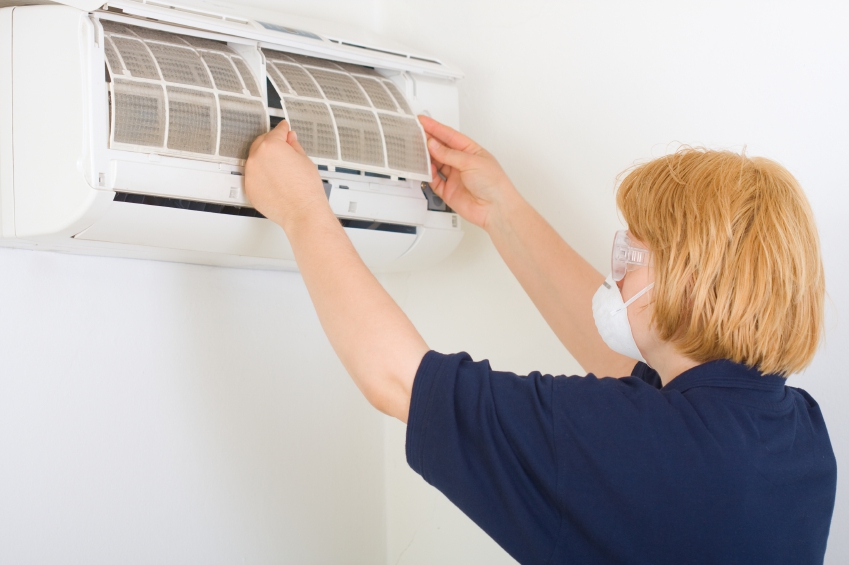 woman cleaning air conditioning unit