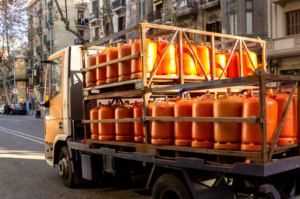 Many orange gas cylinders transported in car