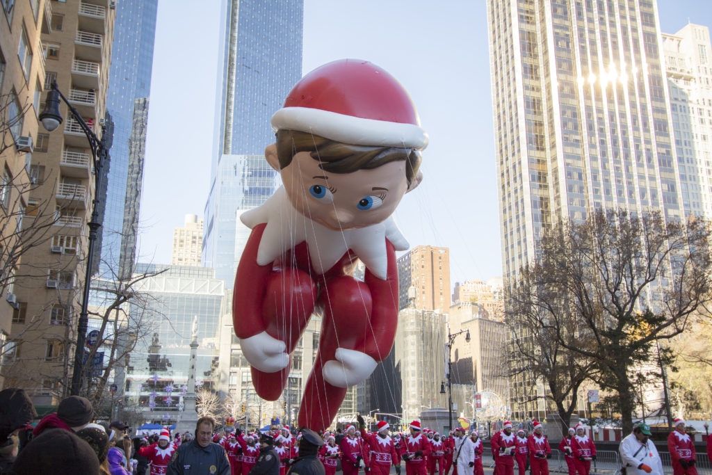 New York City, New York, United States - November 28, 2013 : Elf on the Shelf balloon flying through W 59th ST during the Macy's 87th Annual Thanksgiving Day Parade.