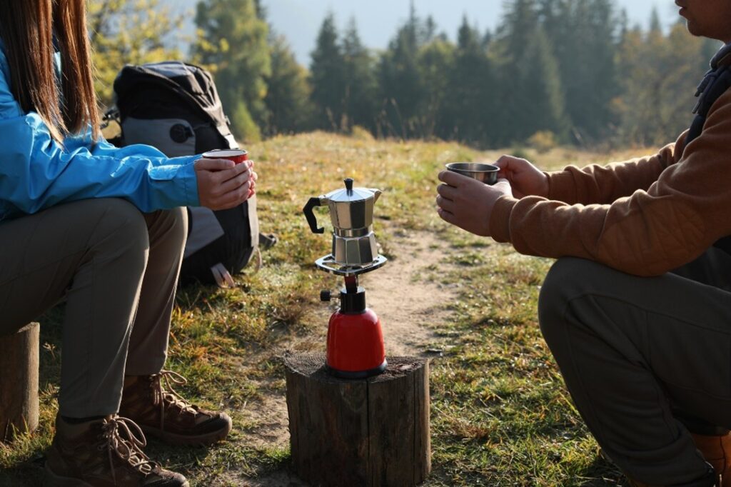 A couple is sat around a camping stove