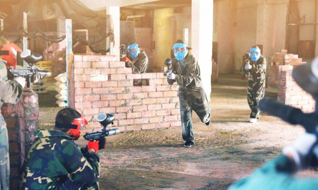 A group of people in masks holding paintball guns