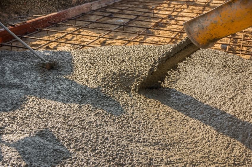 A construction worker pouring cement