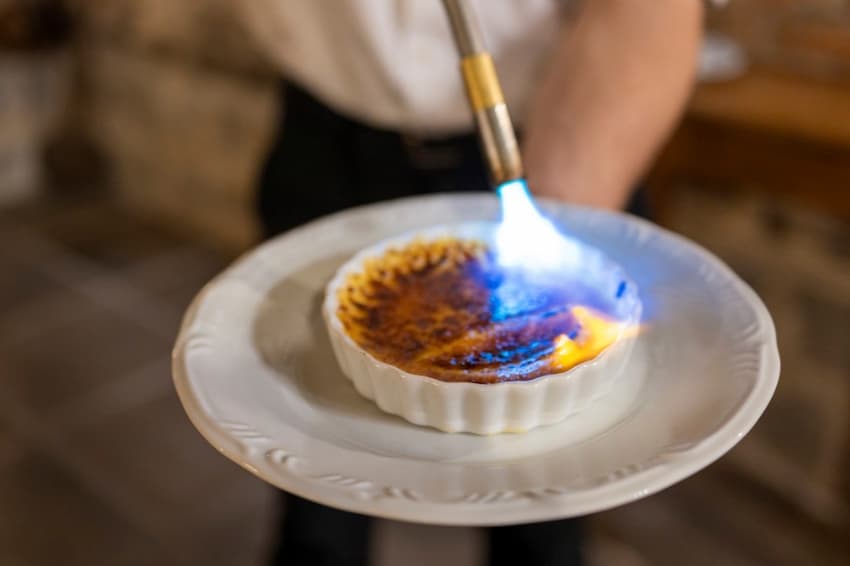 A person holding a plate with a flame on top of a plate