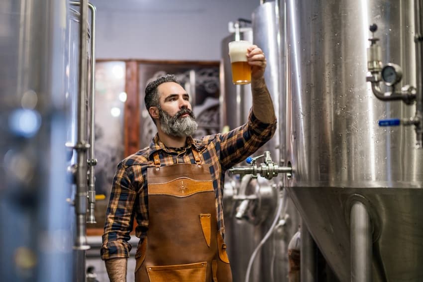 A person holding a glass of beer