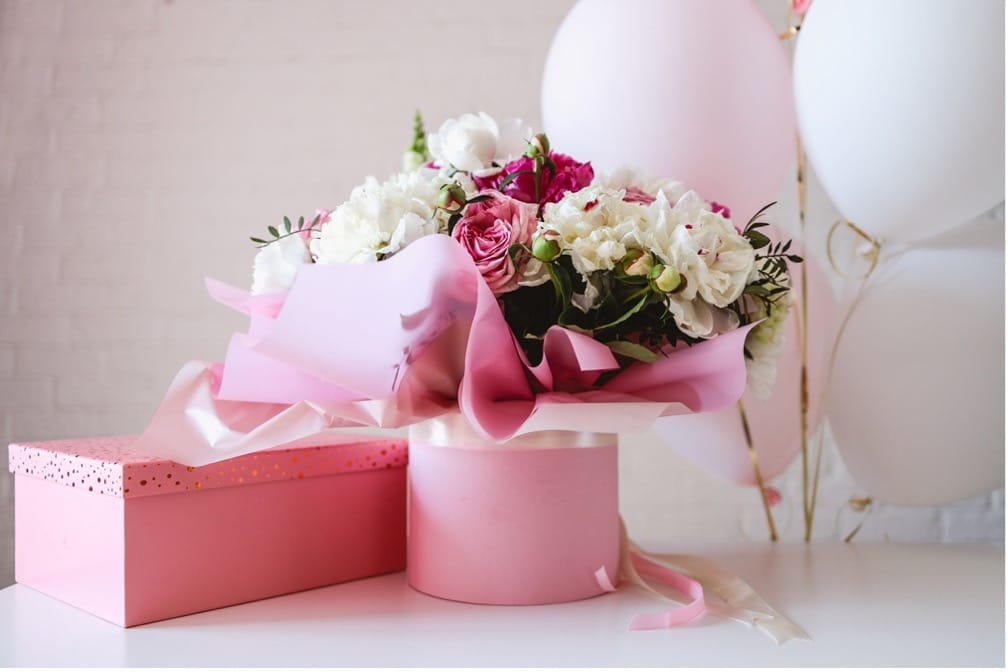 A bouquet of flowers in a pink box