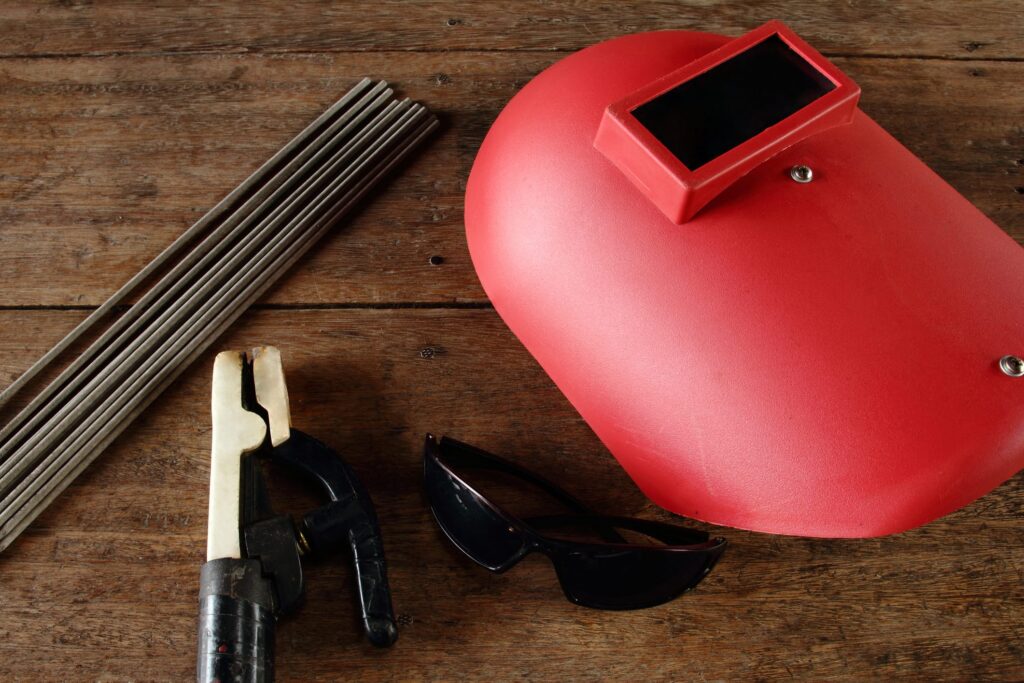 Electric welding tools assortment, including welding rods, mask and other equipment.