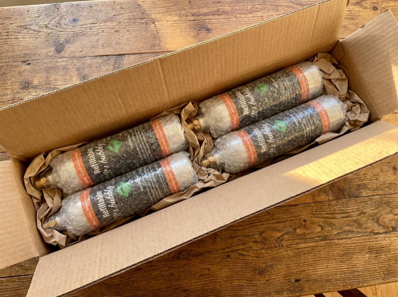 Empty CO2 cylinders wrapped in bubble wrap inside a cardboard box